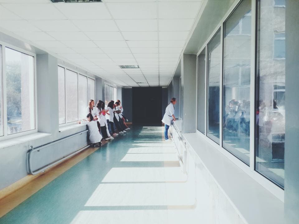 Světlá chodba kliniky s velkými okny